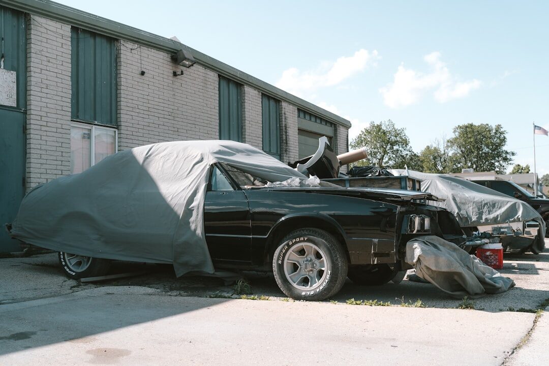 Row of covered classic cars in a dim mysterious private garage