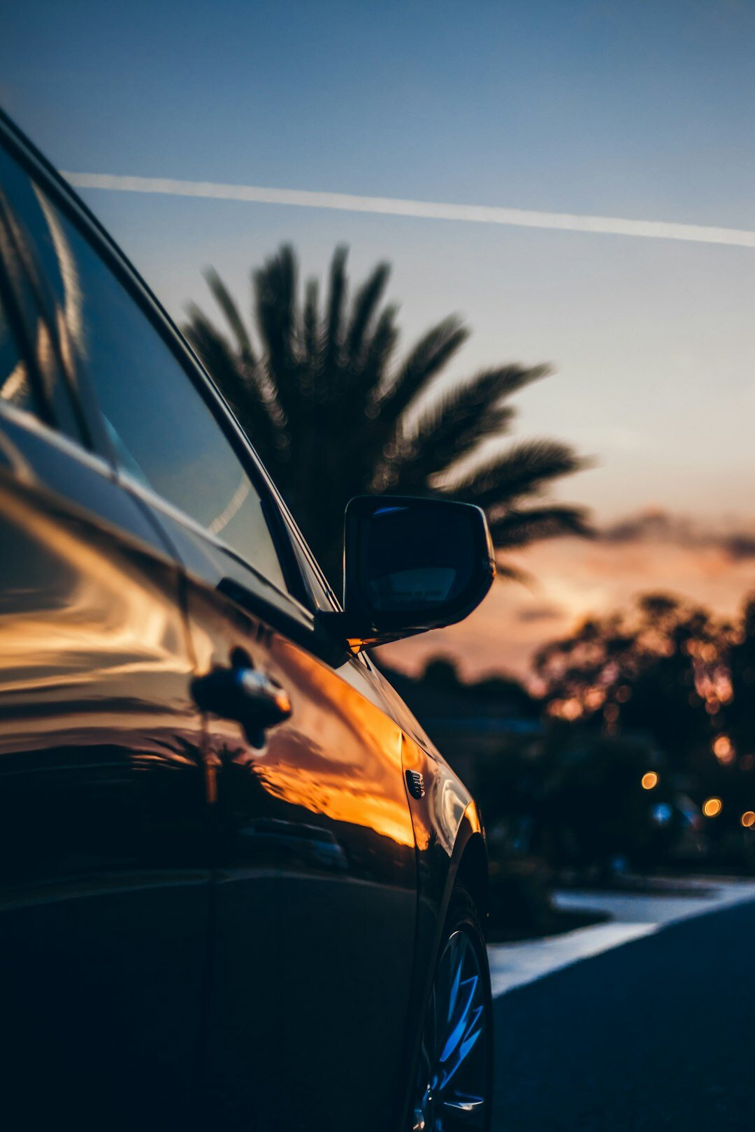 luxury car driving at sunset