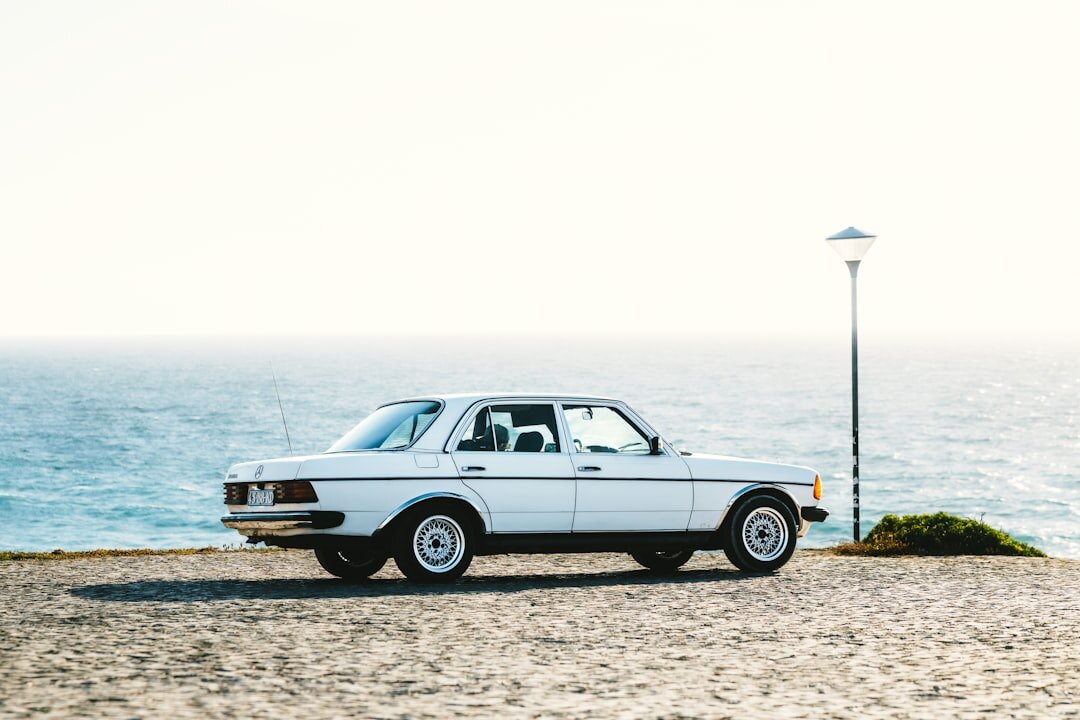 Vintage sports car driving along a coastal road in Punta del Este at dusk